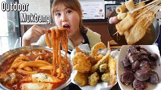 Outdoor Mukbang in Korean tteokbokki restaurant eating noodle tteokboki, odeng, sundae, fried food