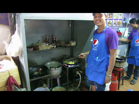 Cook prepares delicious food at street restaurant Sukhumvit road Bangkok - Pantaree