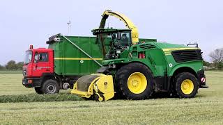 JohnDeere 9500i mit 5 Transport Fahrzeuge im Gras.