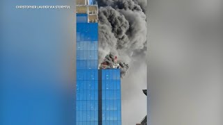 Crane operator rescues man from burning high-rise in England, video shows