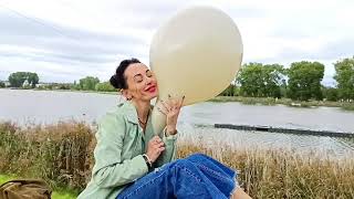Looner Girl Blows Grey Balloon By The River