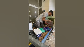 Installing the first row of tile perfectly.