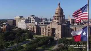 Flags flying with the Texas State Capitol in the background