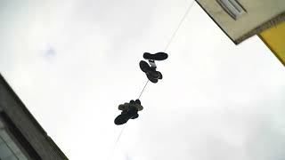 [FREE STOCK VIDEO] Spinning Shot of Shoes Hanging By Their Laces On A Electrical Cable Gangsta