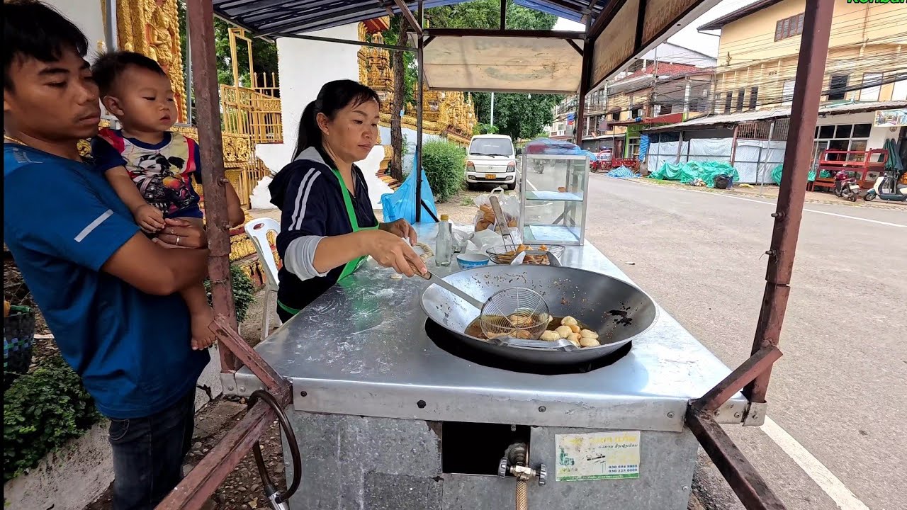 Family makes a living selling Lao donuts in front of Wat Sysavath in Vientiane, Laos.