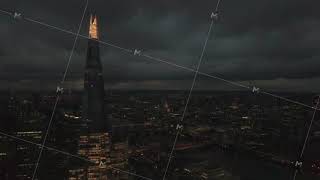 The Shard skyscraper in London city, UK. Aerial drone view of capital cityscape at night, dolly in