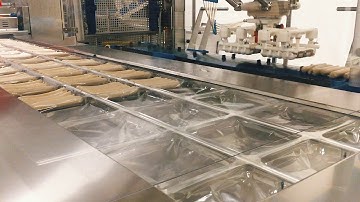 Loading of sausages into a thermoforming machine