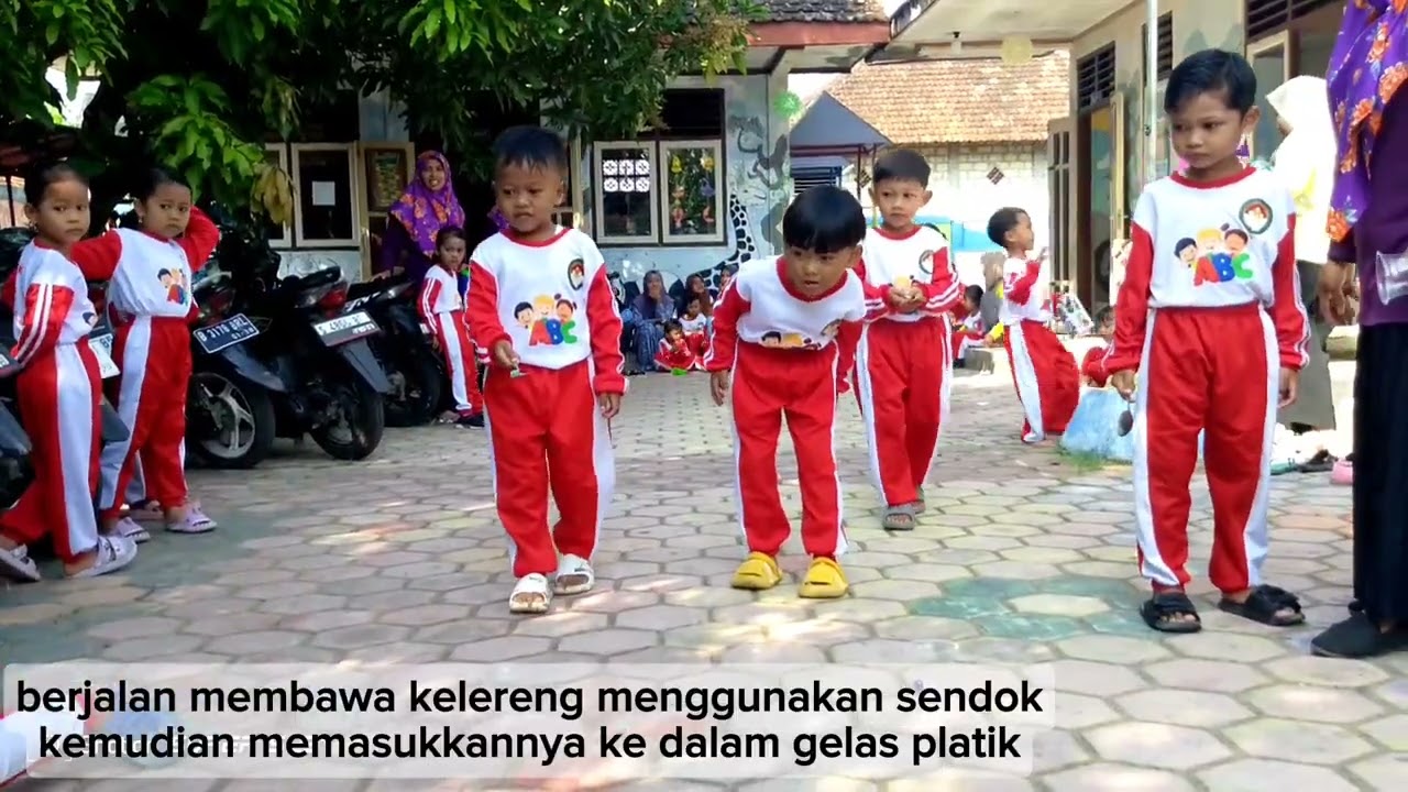 berjalan membawa kelereng menggunakan sendok kemudian memasukkannya ke dalam gelas platik