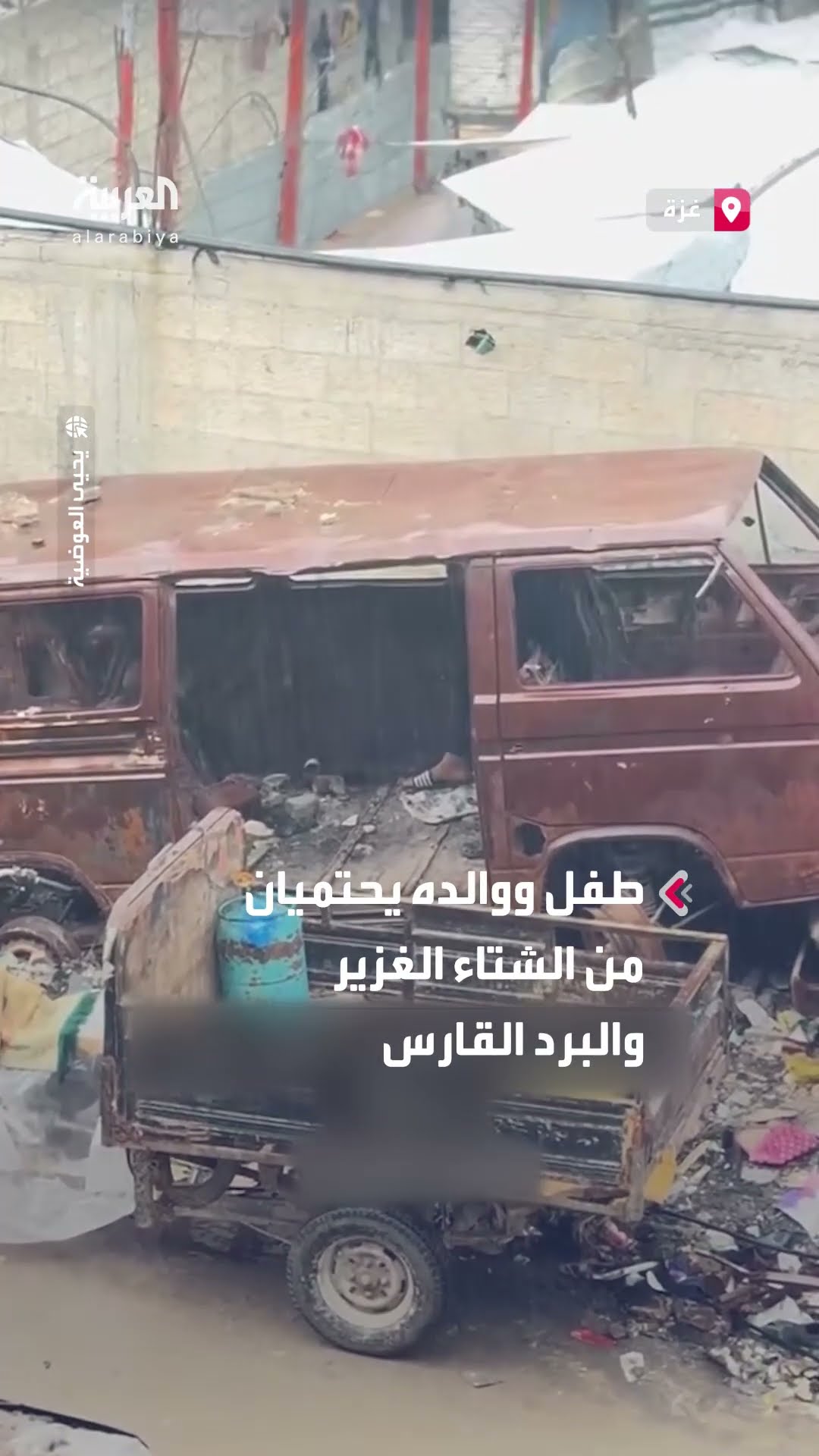طفل ووالده يحتميان من الشتاء الغزير داخل مركبة محترقة ومدمرة بغزة