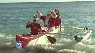 Santa Claus makes a visit to Waikiki via canoe