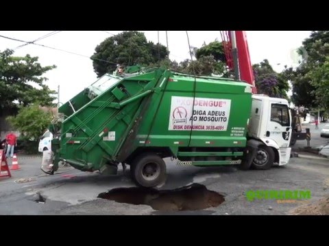 Caminhão da coleta de lixo é quase engolido por buraco na rua
