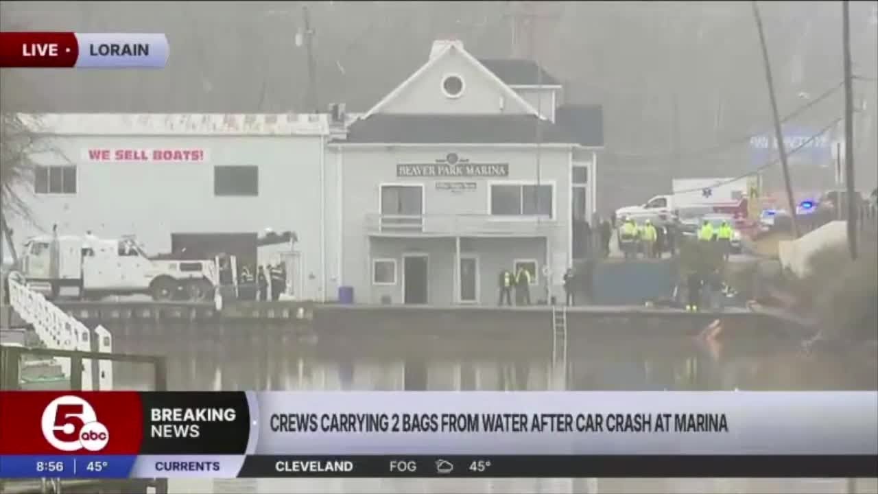 Crews carry 2 bags from water after crash