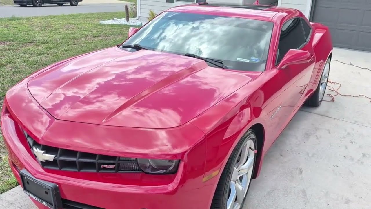 Before and after paint restoration of a red 5th Gen Chevrolet Camaro RS by Primal Detailing in Jacksonville’s Westside. High-gloss mirror reflection achieved through acid decontamination, clay bar, and Nano-Care Banana Wax application.