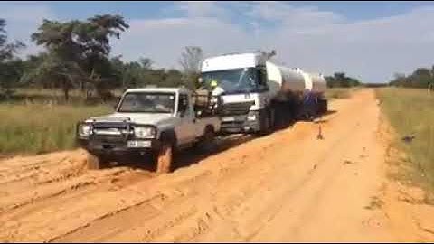 Landcruiser pulls out truck stuck in mud
