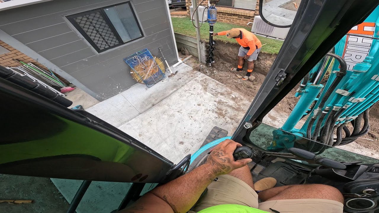 installing concrete sleeper retaining wall post and excavation prep