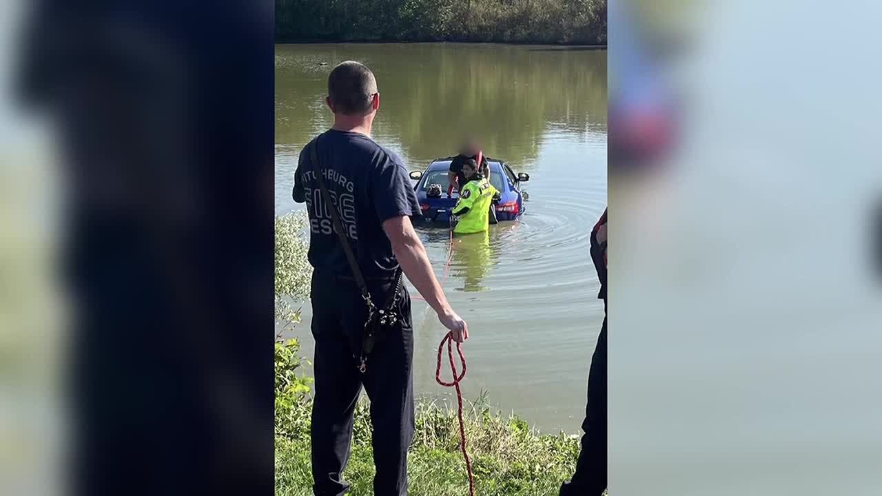 Fitchburg firefighters rescue person standing on car in retention pond