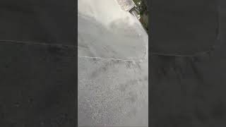 Skateboarder ride up ramp at skatepark and crashes into boy wearing full face helmet on scooter