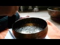 Slowmotion singing bowl filled with water