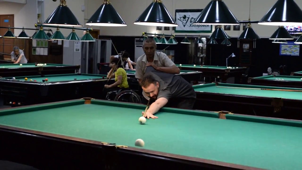 Мужик в городе учится играть в бильярд