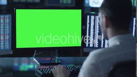 Man is Working on a Computer with Mock-up Green Screen in a Dark Office | VideoHive 14926558