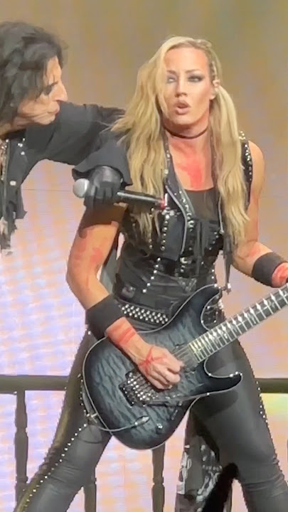 Nita Strauss tearing it up while Alice Cooper watches like a proud villain.