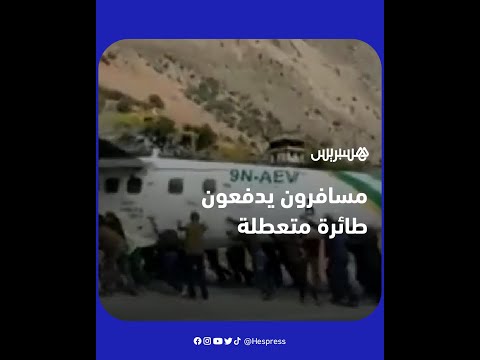 ركاب وموظفون يدفعون طائرة متعطلة على المدرج لإفساح المجال لهبوط طائرة آخرى