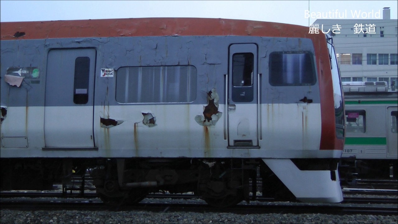 鉄道車両の窓ガラス NEX 253系 クロ253‐1 なごり雪降る夕刻 窓明かり漏れる車両が通過する