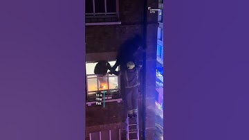 Moment firefighter rescues man dangling from window ledge to escape fire