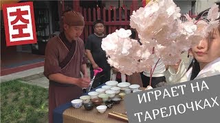 Китаец играет на фарфоровых тарелочках. Город Хэндянь, Китай. "Hengdian World Studios" - киностудия