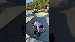 BMX rider jumps ramp gap at skatepark then falls forward and faceplants