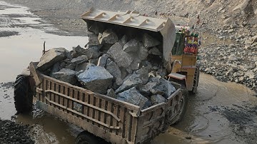 This Caterpillar Wheel Loader is a Powerful Giant: 966E Loading Big Rocks into Huge Trolleys