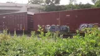 One BNSF and 3 Norfolk Southern engines pulling Northbound freight, and rocks.