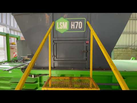 Staff loading waste into the H70 baler