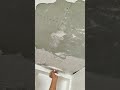 applying drywall compound to a ceiling with a trowel for smooth finishing in construction renovation