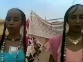 Chadian women with long hair dancing and singing during ceremony.