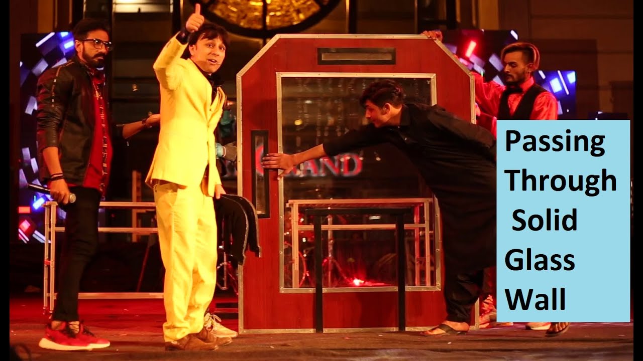 Passing through Solid Glass wall illusion under audience inspection, illusionist Munawar Khan