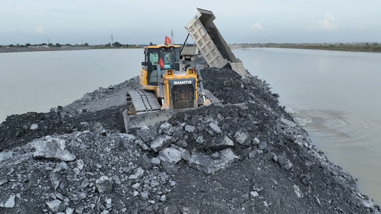 Construction of a road over water, quarrying and filling , dozers ...