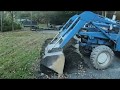Digging a drainage swale on the edge of a driveway