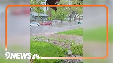 Trash can floats down street after heavy rain