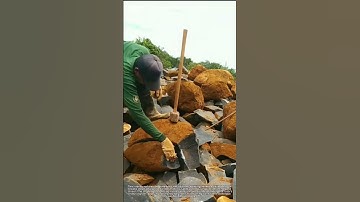 Stone Mason Splits Large Rock into Small Pieces with Hammer