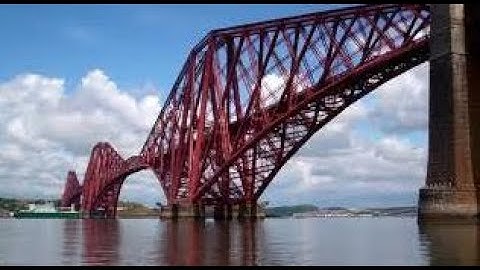 Spring Cargo Ship Sailing Under Forth Railway Bridge On History Visit To Firth Of Forth Scotland
