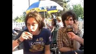 Julian Casablancas skulling a shot, drinking a beer, and smoking a cig