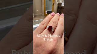 A beautiful oval Ruby and diamond side stone trilogy ring set in 18ct yellow gold.