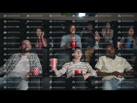 Slow motion of men and women yawning drinking watching boring movie in cinema