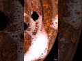 Hand cleaning rusty car wheel