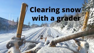 Clearing SNOW off road with grader.  North Idaho.