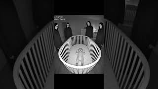 12:29 AM — B&amp;W Nursery Cam — Silent figures stand evenly spaced around the crib. The baby cries as