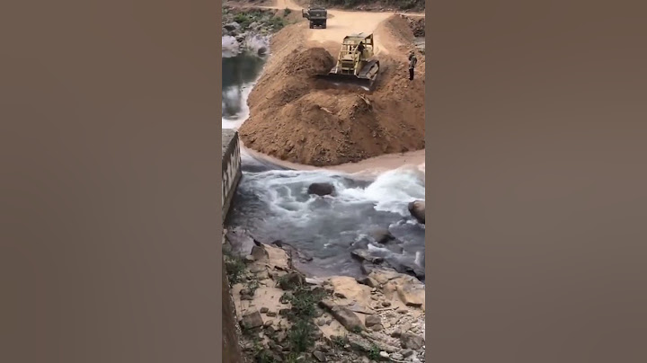 Buldozer blocking a river