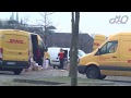 DHLPaketboten werfen Patkete über Parkplatz