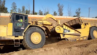 CAT 657G and 651B scrapers moving dirt  D9T Dozer ripping and pushing